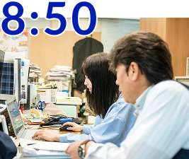 メールチェックをする女性社員と男性社員